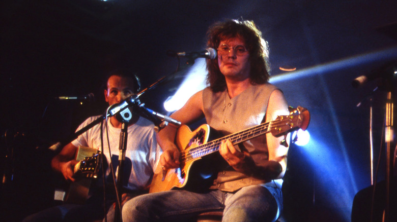 Def Leppard performing live while seated in 1995