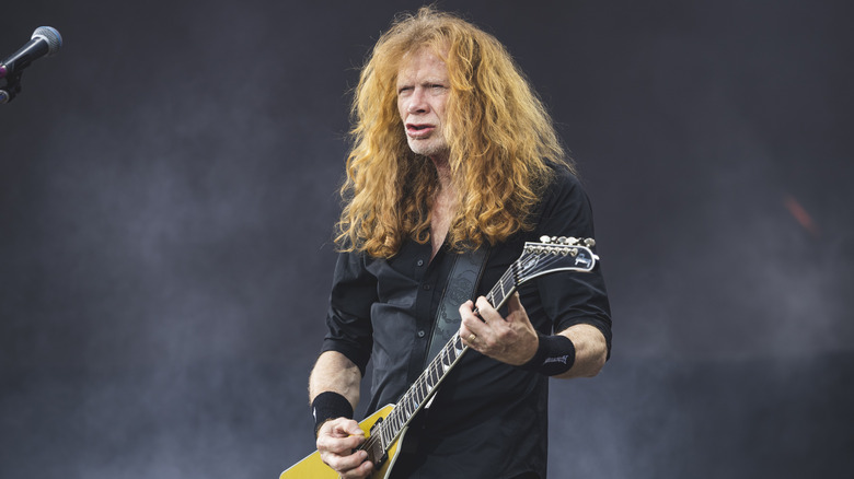 Dave Mustaine playing guitar on stage at a festival.