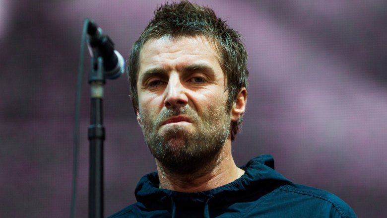 Liam Gallagher sneering behind microphone stand