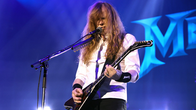 Megadeth's Dave Mustaine playing guitar and singing on stage in 2026