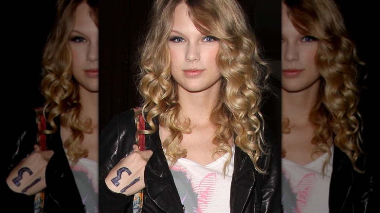 Taylor Swift with a 13 written on her hand