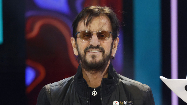 Ringo Starr posing in front of a colorful background