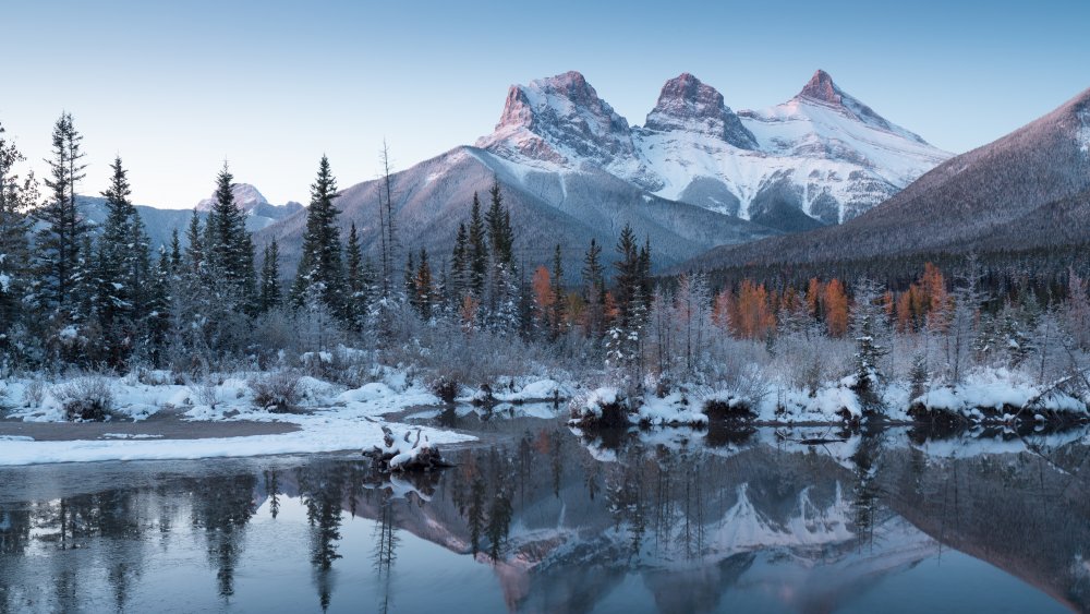 Icy lake with snowy mountains in background