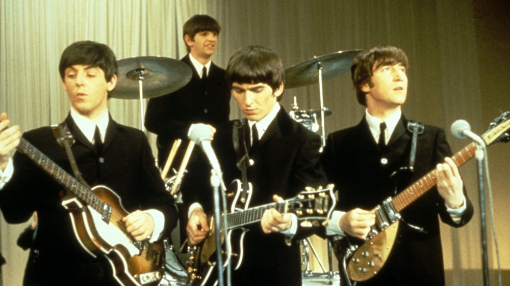 Beatles playing onstage black suits