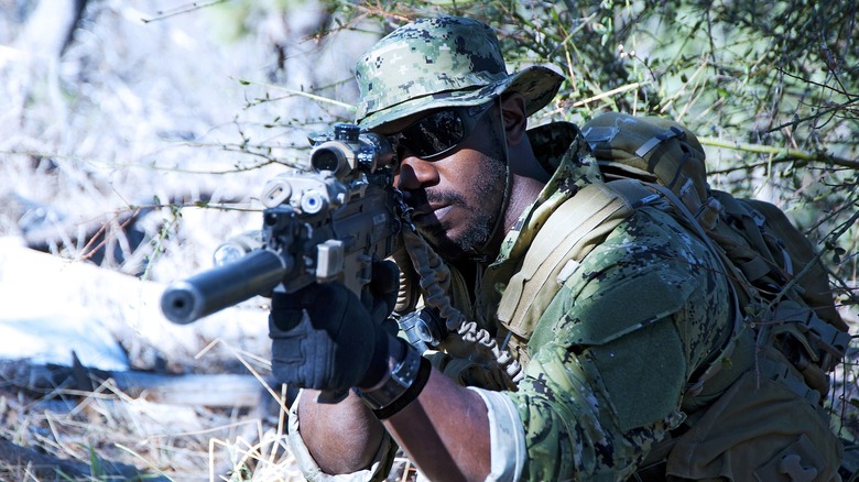 A soldier aims his rifle