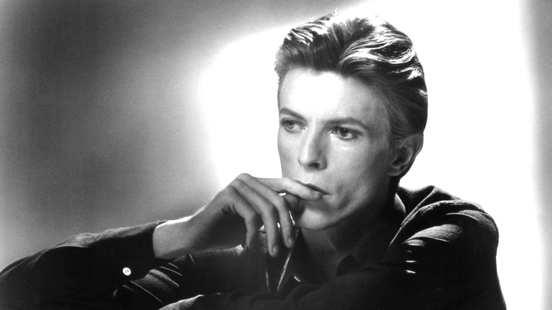 David Bowie posing for portrait with hand to lips