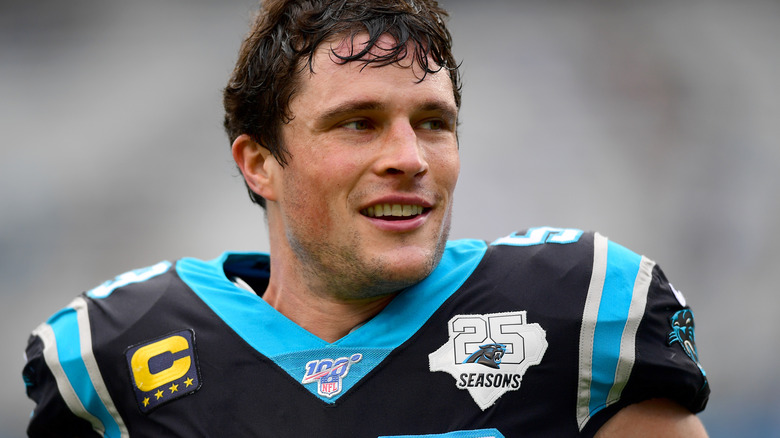 Luke Kuechly smiling in black blue Carolina Panthers jersey
