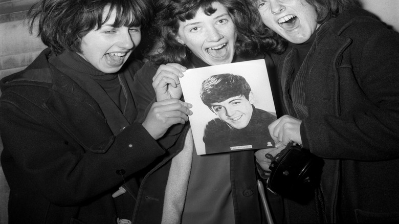 Teenage fans holding picture of Paul McCartney