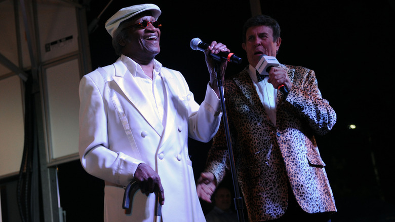 Bobby Lewis in white suit performing on stage