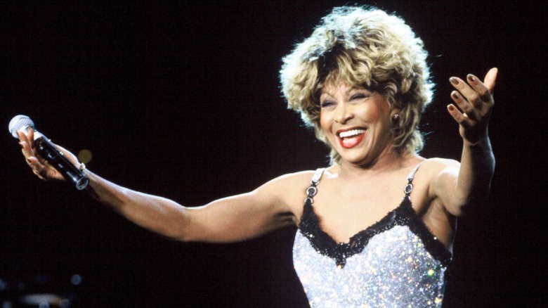 Tina Turner holding out her hands and smiling during a concert