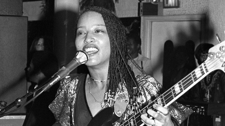 Janice-Marie Johnson of A Taste of Honey smiling and playing bass guitar