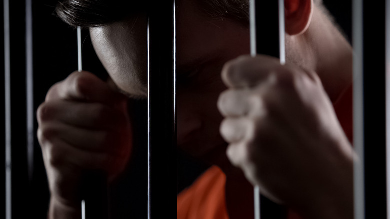 Man behind prison cell bars