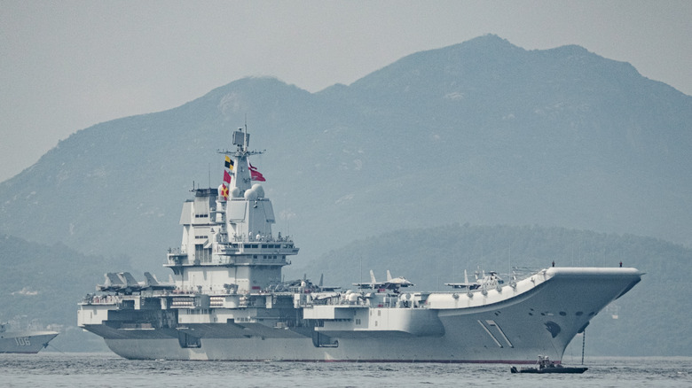a chinese aircraft carrier docking in hong kong