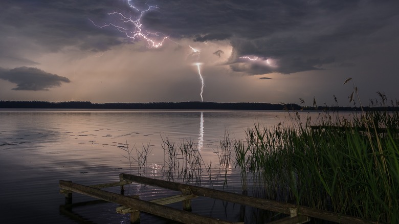 panorama of lightning strikes over a lake in poland