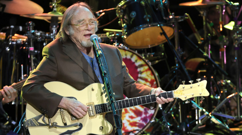 Stephen Stills singing and playing electric guitar on stage