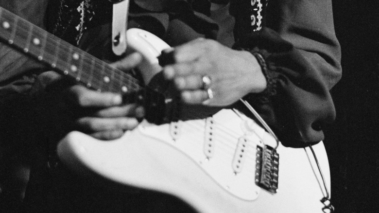 A closeup shot of Jimi Hendrix's hands as he plays a Fender Stratocaster in 1968