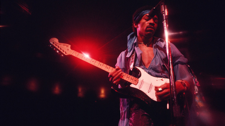 Jimi Hendrix playing guitar on stage in 1969