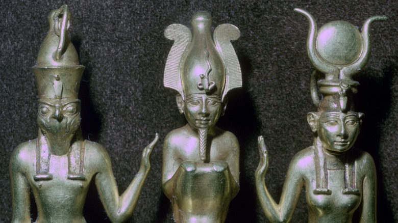 Ancient Egyptian figures of Isis, Osiris, and Horus