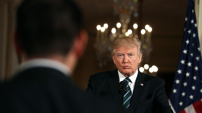 Donald Trump at podium pursing lips