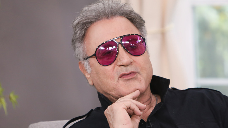 frank stallone wearing rose glasses touching chin