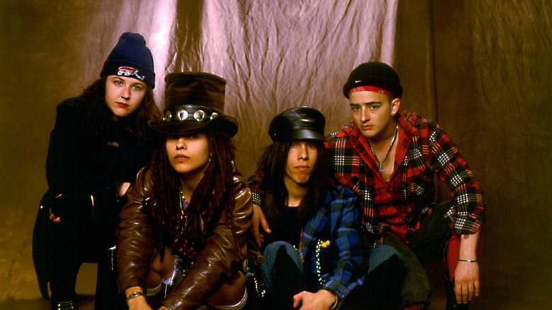 four non blondes pose in front of a curtain in 1990s promo shot