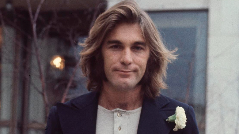 dennis wilson smirking in a blazer in posed shot