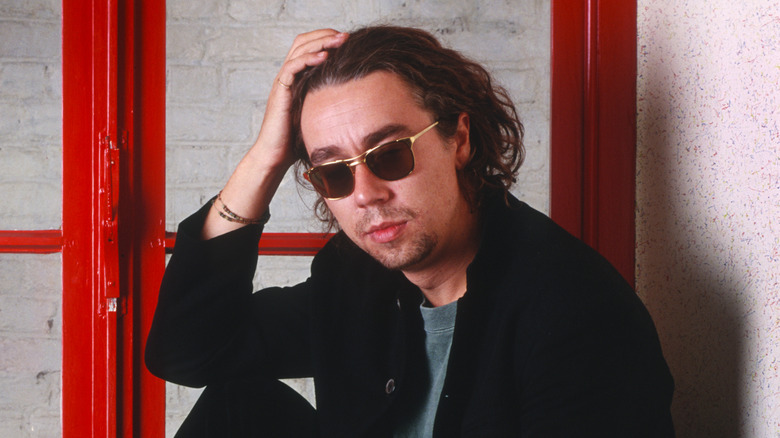 Karl Wallinger of World Party wears sunglasses and pushes back hair