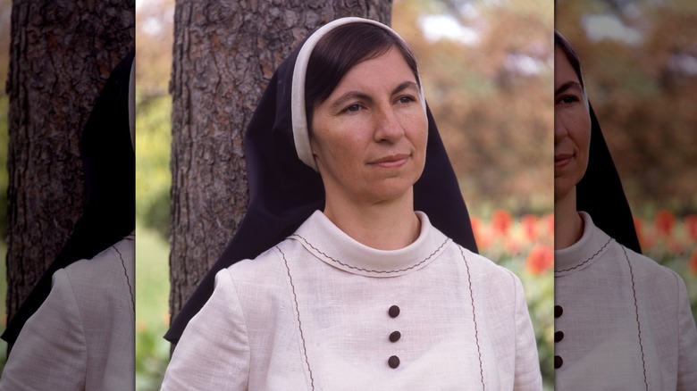 Sister Janet Mead in nun habit stood by tree