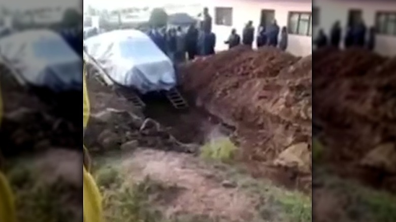 car being lowered into grave