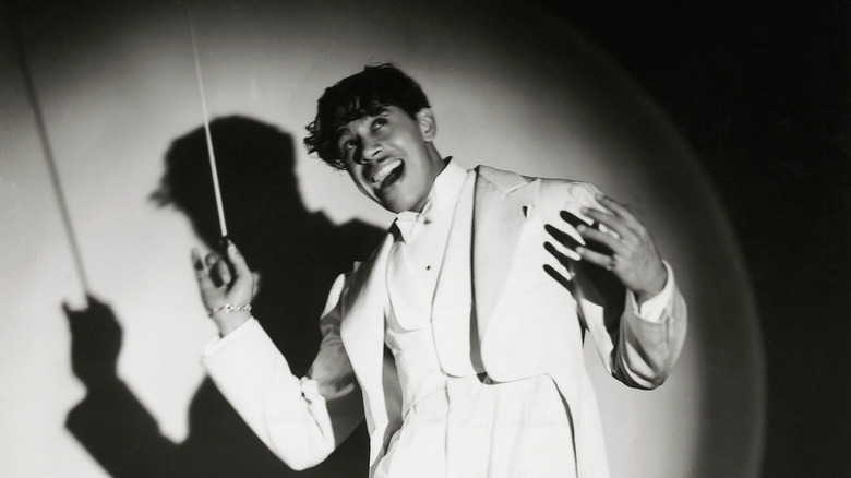 Cab Calloway posing in spotlight with baton