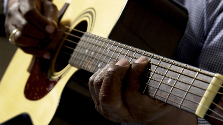 Guy playing guitar hands closeup