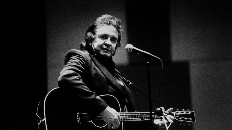 Johnny Cash playing guitar on stage