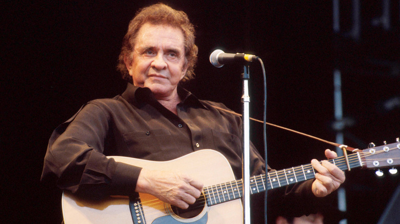 Johnny Cash playing guitar on stage
