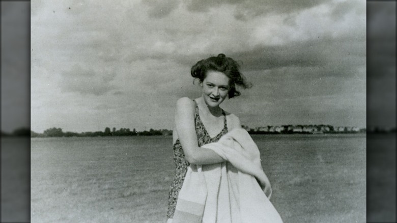 Woman swimsuit holding blanket in field