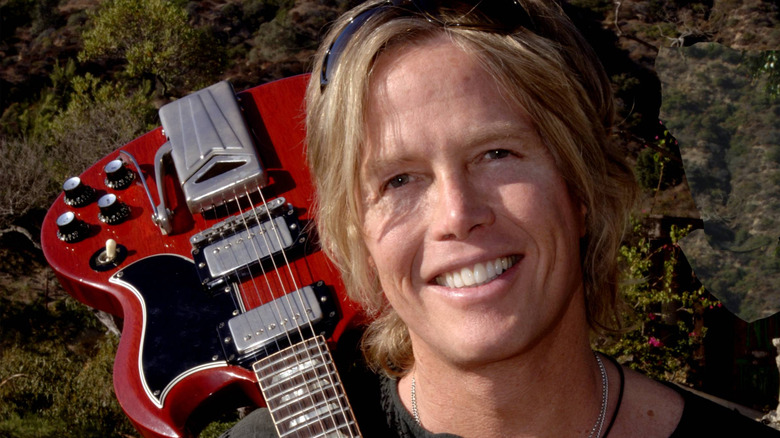 Brian Ray holding a red guitar