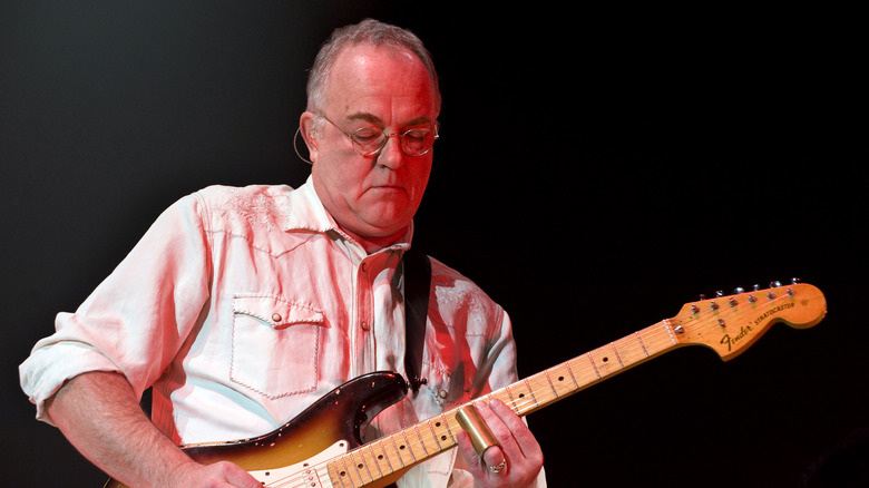 Robbie McIntosh playing guitar during a concert