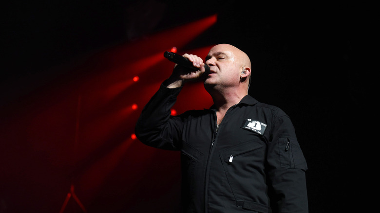 David Draiman singing while holding a microphone on stage