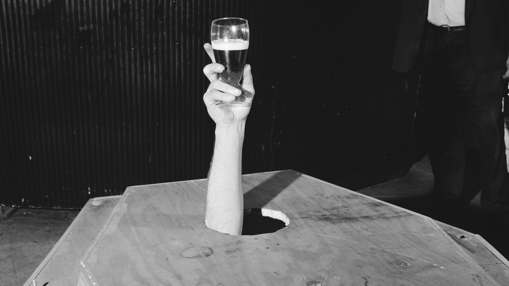 Mick Meaney hoisting a beer before being buried