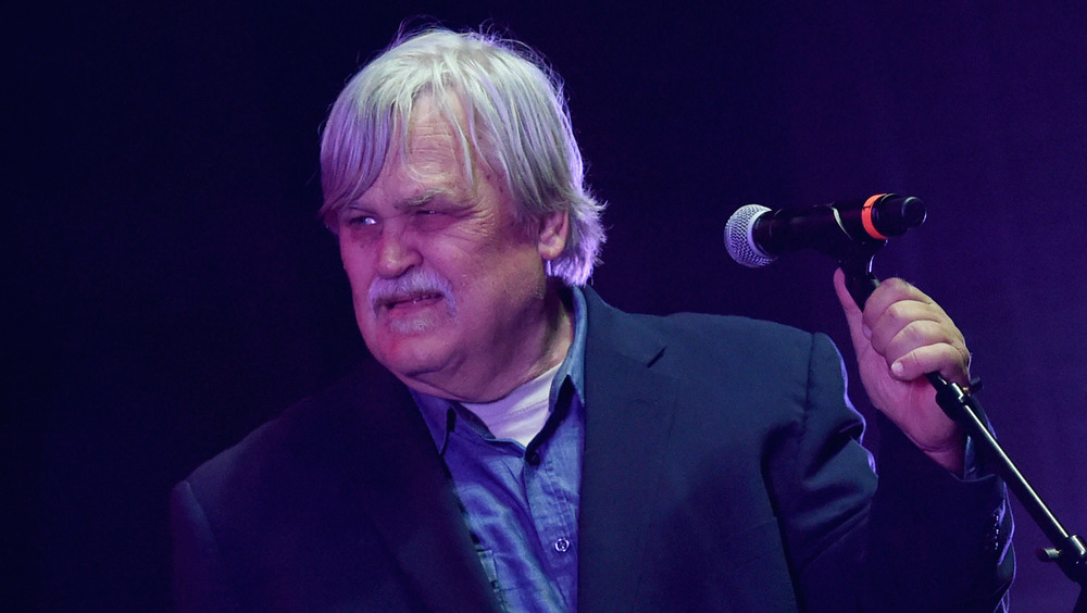 Col. Bruce Hampton moustache suit holding mic