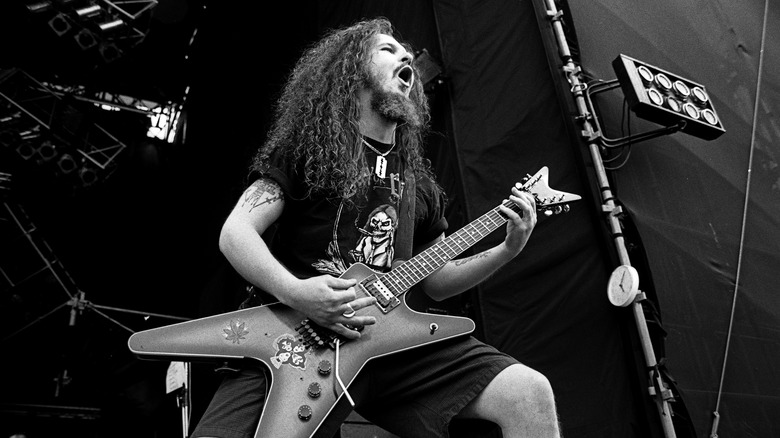 'Dimebag' Darrell playing guitar singing on stage