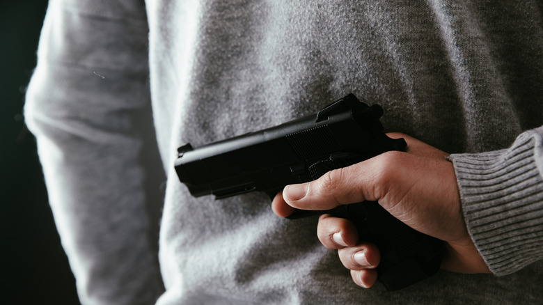Gun concealed behind man's back