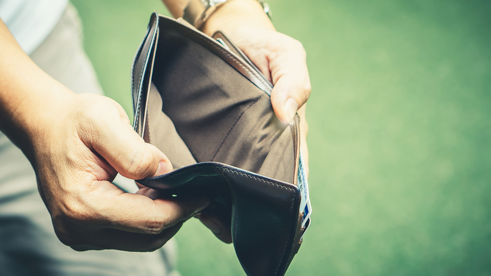 Man looking into an empty wallet