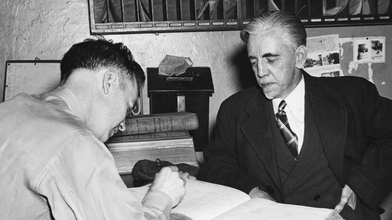William Dudley Pelley in suit being processed by police