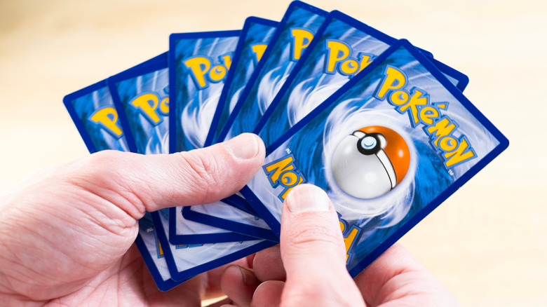 hand holding out array of Pokemon cards