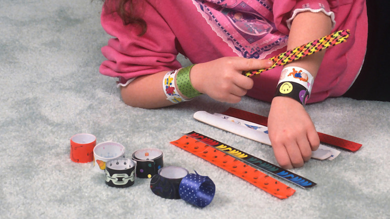 girl playing with slap bracelets
