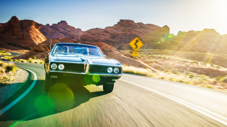 Vintage car speeding down a desert road