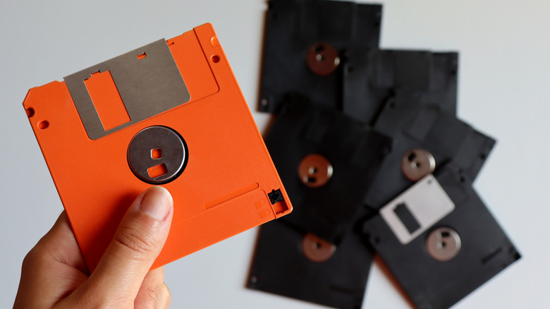 Hand holding a floppy disk