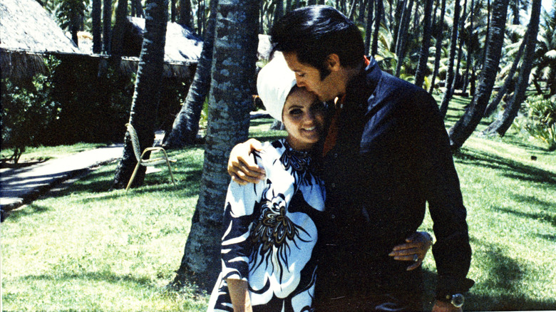 Priscilla and Elvis Presley embracing outside