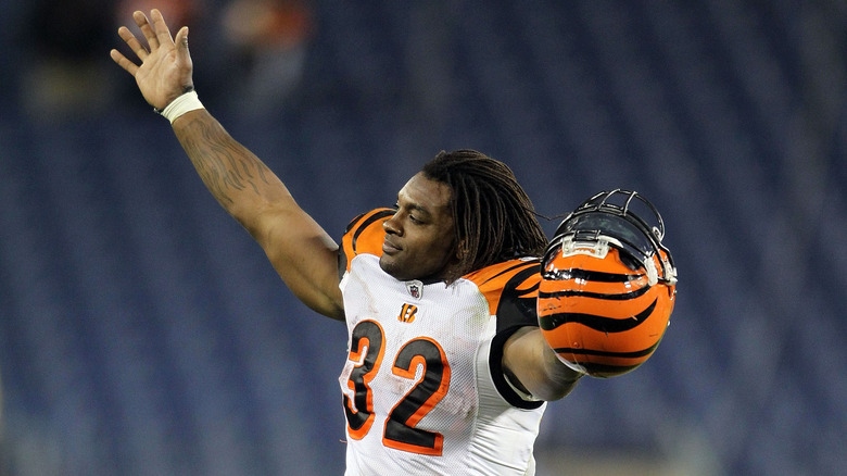 Cedric Benson celebrating in a Bengals jersey holding his helmet