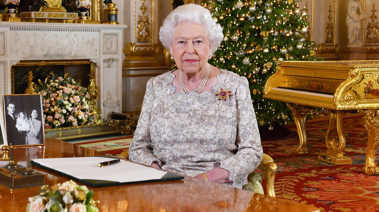 Queen Elizabeth II seated at desk